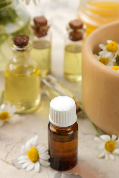 istock Medicinal chamomile and chamomile extract in a bottle. oil from chamomile flowers. aromatherapy. a drug. on a light concrete table. 1420561898