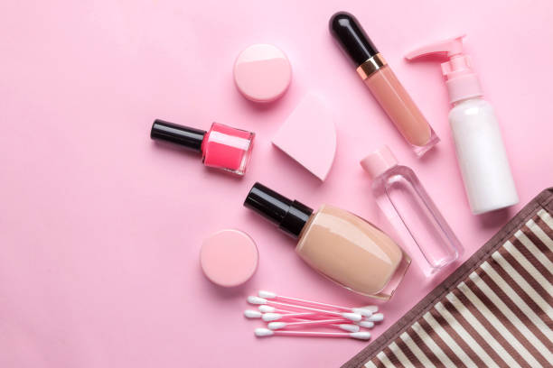 istock makeup kit. Women's cosmetics in a cosmetic bag and makeup brushes on a pink bright background. women things. top view 1420564747