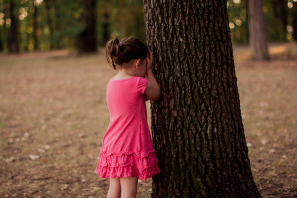istock Girl playing hide and seek in public park 1420571030