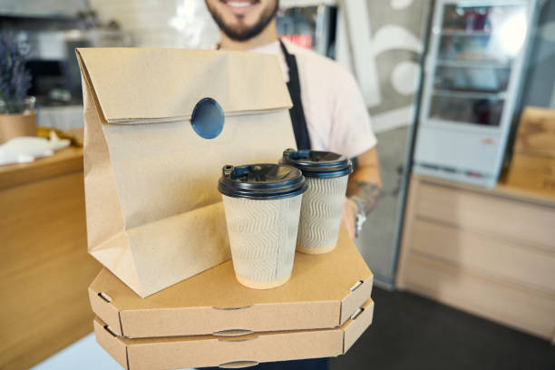 istock Ready-made boxes with takeaway pizza and drinks in barista hands 1420573124