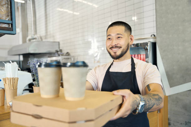 istock Smiling brunette man giving packed food takeaway order 1420573129