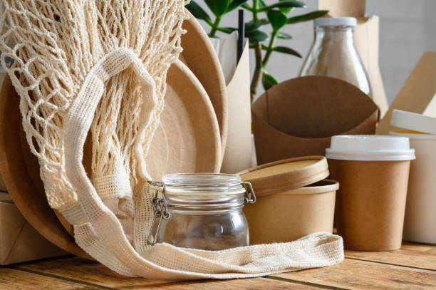 istock Eco-friendly paper and glassware. A reusable shopping bag in the foreground. Selective focus on glass jar and shopping bag. The concept of saving the environment and nature. 1420578551