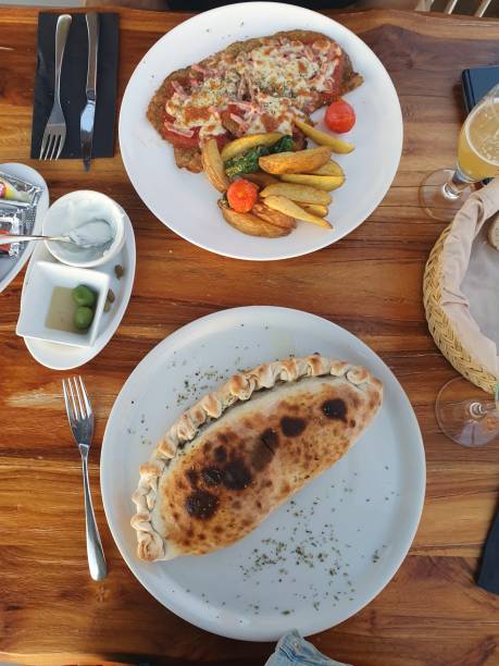 istock Food at a restaurant table. Calzone 1420578672