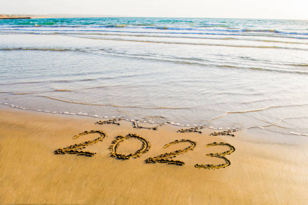 Happy New Year 2023 happy new year 2023 text on the sea beach. Abstract conceptual photo of coming New Year 2023 and leaving year of 2022 january stock pictures, royalty-free photos & images