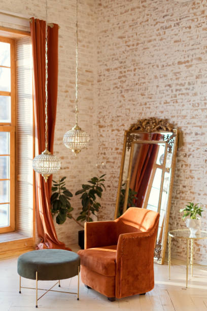 Interior in oriental style with terracotta color armchair, vintage golden mirror and crystal chandelier