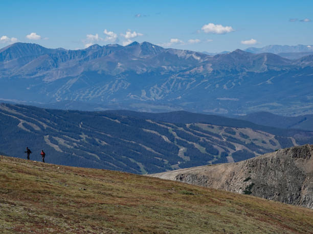 Two hikers high in the Colorado mountains, Keystone and Breckenridge ski resorts behind. stock photo