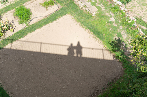 Shadow of a couple on top of a bridge on a sunny day
