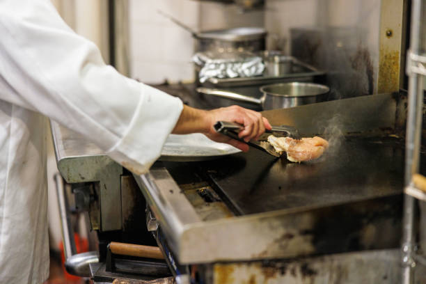 Close-up of a man roasting meat on a commercial kitchen