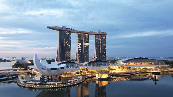 Marina Bay, Singapore - July 13, 2022: The Landmark Buildings and Tourist Attractions of Singapore. The MBS Hotel with The Shoppes and Art museum, shot during dusk and sunrise with a drone