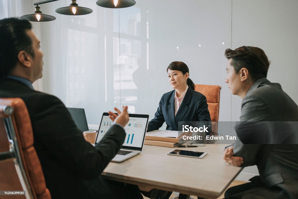 Diversify mid adult Asian business person discussion in meeting room Assertiveness Stock Photo