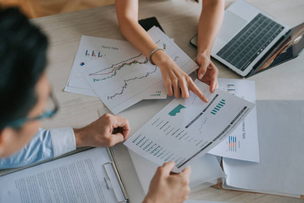 close up high angle Asian businesswoman working with her coworker in meeting room close up high angle Asian businesswoman working with her coworker in meeting room financial report stock pictures, royalty-free photos & images