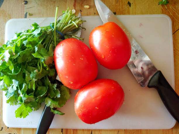 tabla de picar tomate cilantro - long coriander fotografías e imágenes de stock