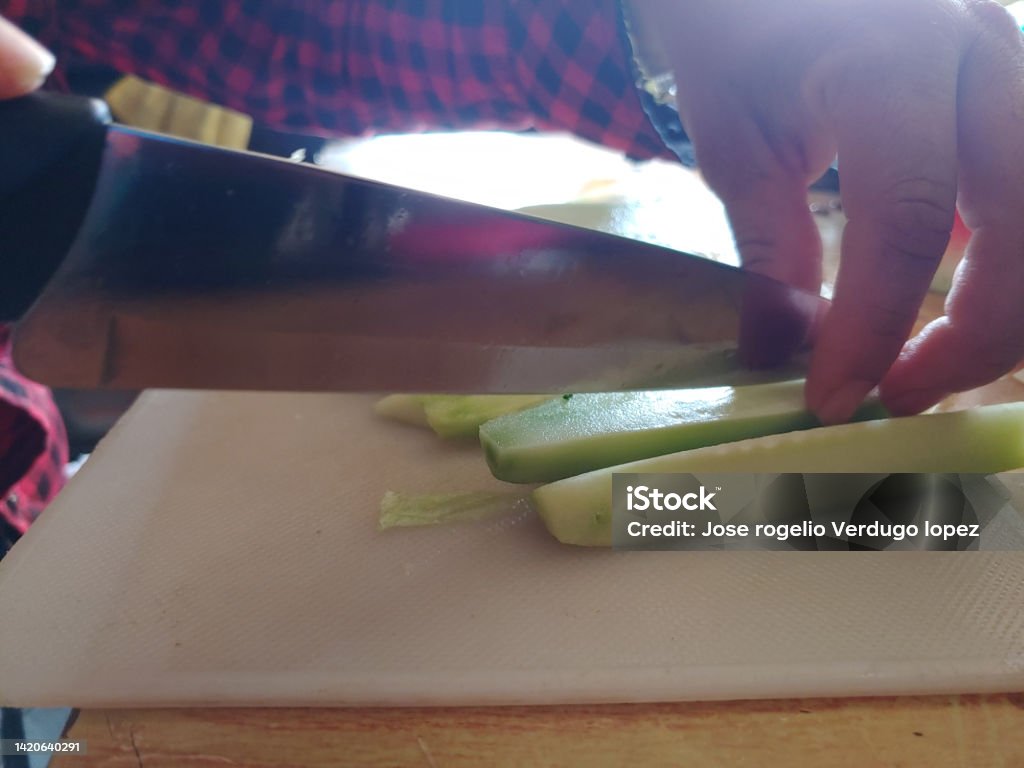Cutting cucumber with a knife Color Image Stock Photo