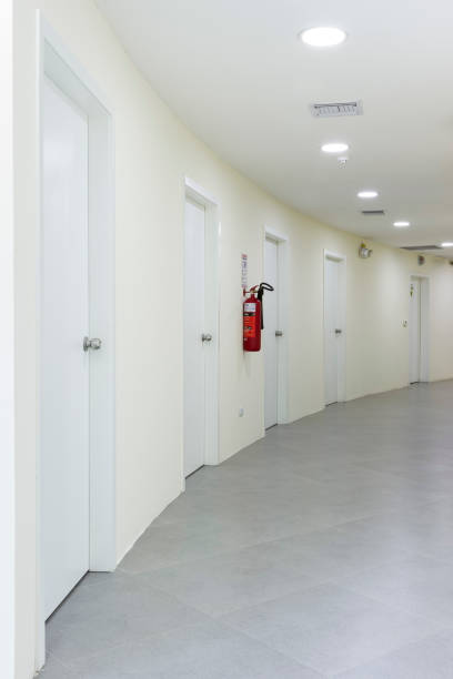 istock Hallway of a building with several doors and access to different rooms, all in white and ceramic floor. Vertical photography. 1420644016