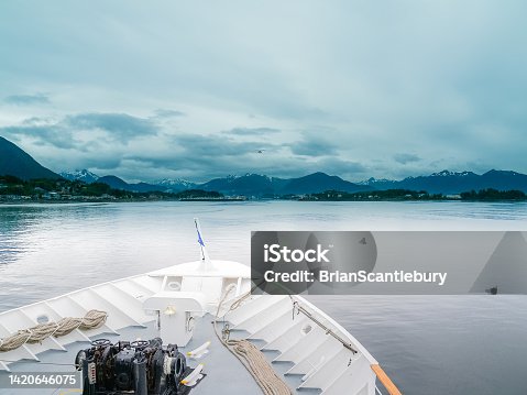 istock Bright white structure and bow of small cruise-ship heading into Alaskan port 1420646075