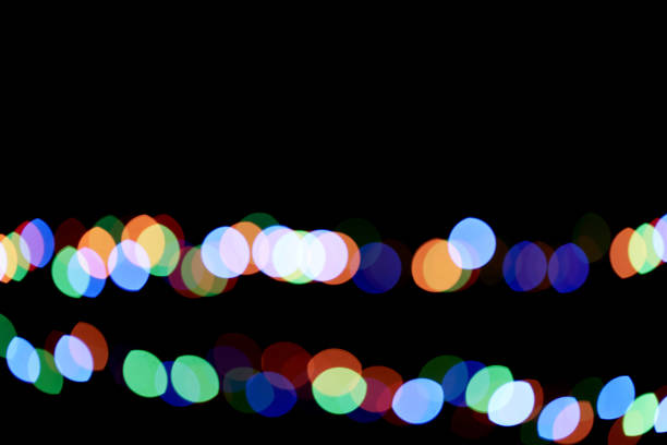 Two multicolored garlands, defocused bokeh lights on an isolated black background. Abstract magic background with bokeh effect. To overlay your design. High quality photo