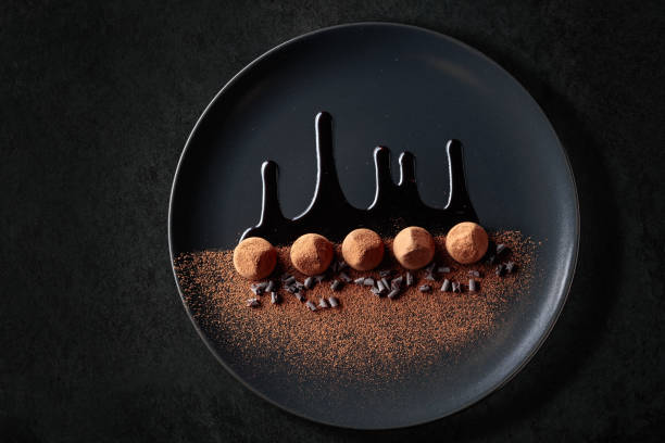 istock Chocolate truffles on a black plate with chocolate sauce. 1420661764
