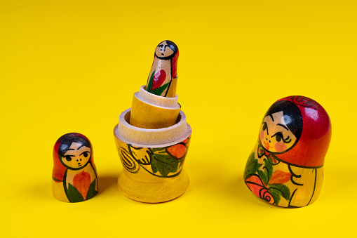 the matryoshka statuettes open on a yellow surface
