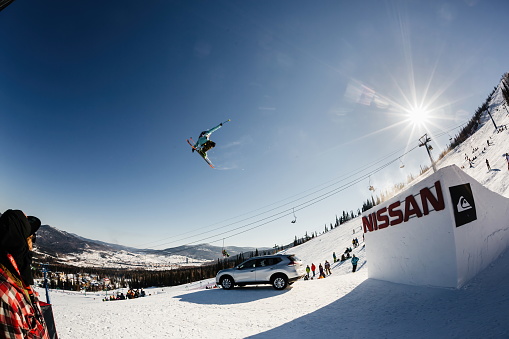 A skier with a grip jumps from a large springboard in a contest - MAR 08, 2015 Sheregesh, Russia