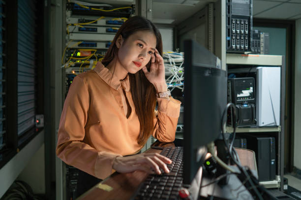 istock A female programmer is working in a server room. The girl is standing next to the computer racks of the data center. The administrator looks at the monitor with network settings. 1420670893