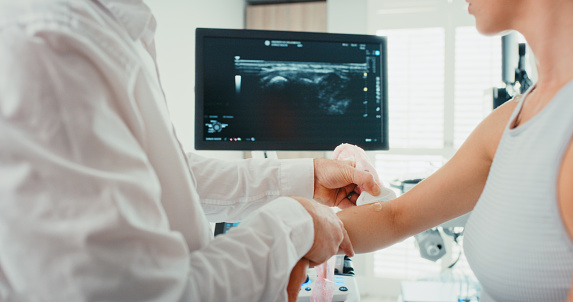 Doctor check ultrasound of patient arm in a clinic for medical and healthcare research at a hospital. Woman consulting with surgery professional with science technology for pain or arthritis therapy