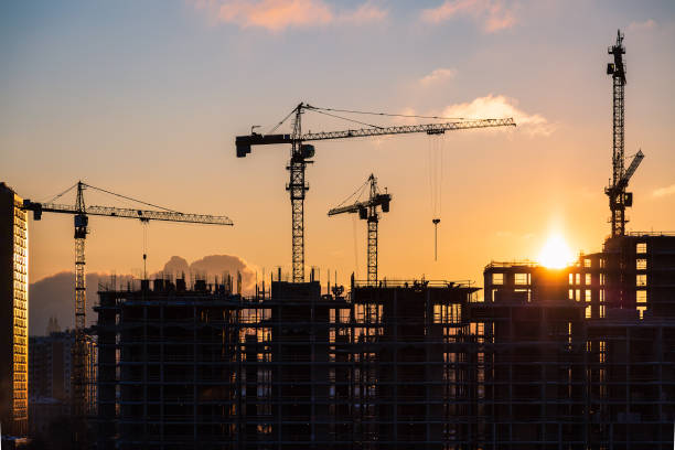 建物夕暮れ時のサイト - crane tower crane construction silhouette ストックフォトと画像