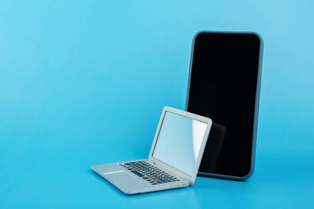 istock phone and laptop on blue background, buying modern gadgets, copy space 1420679930