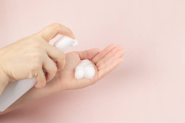istock face wash, Cosmetics foam pump container bottle in a woman's hand 1420679942
