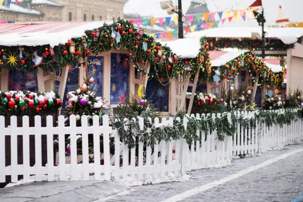 christmas market,stall houses with gifts,decorated fence with trees,atmospheric background with lights