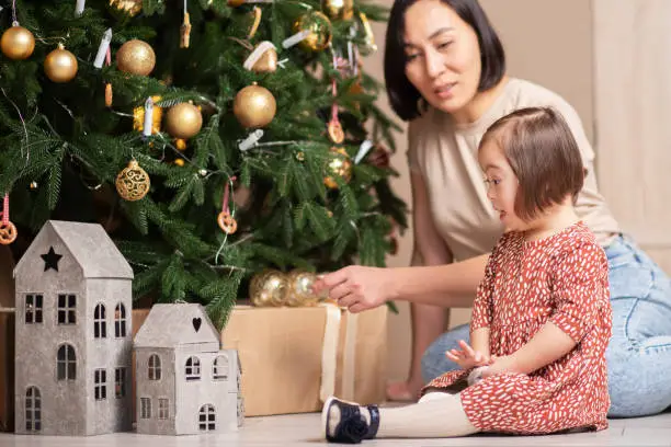 happy family christmas,child with down syndrome with mom at christmas tree