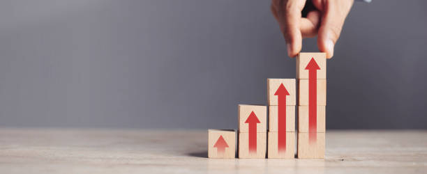 istock businessman hand  arranging wood block stacking as step stair with arrow up.concept for business growth success process. 1420680556