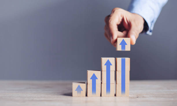 istock businessman hand  arranging wood block stacking as step stair with arrow up.concept for business growth success process. 1420680558