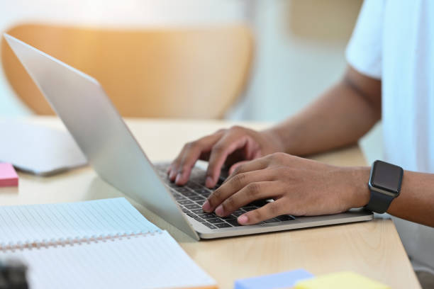 istock Cropped view businessman sitting in an office pressing a keyboard and using a laptop for business and technology concept. 1420683593