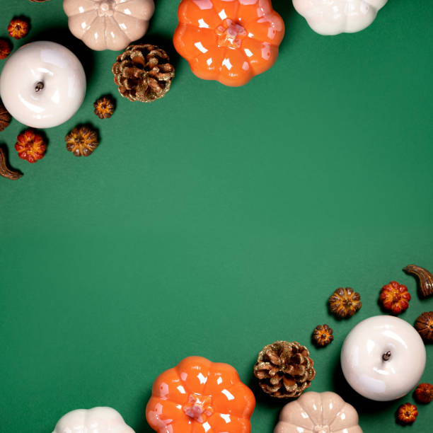 istock Autumn border with ceramic pumpkins, pine cones and autumn decor on dark green background 1420683676