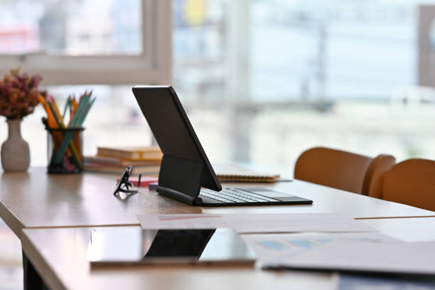 istock Workplace desk with tablets and paperwork with no people, for business and technology concept. 1420684539