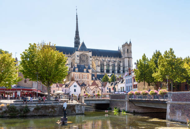 catedral de notre-dame d'amiens e o homem em boia por stephan balkenhol em amiens, frança. - church window rose window old - fotografias e filmes do acervo