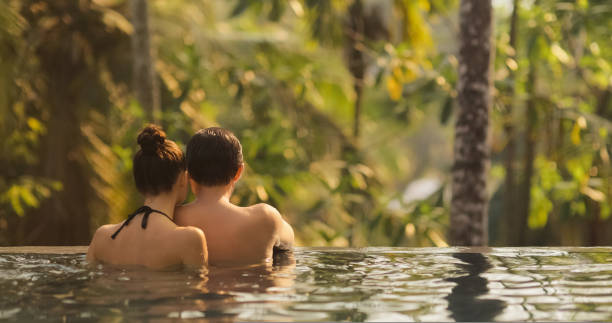Couple in Love Together in Infinity Swimming Pool Outdoors During Tropical Vacation stock photo