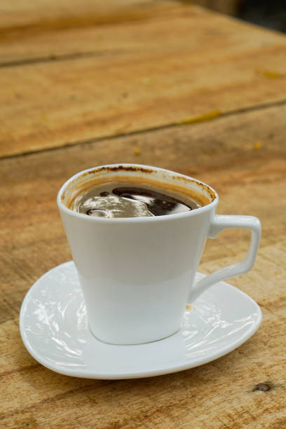 istock Cup of coffee in white cup on wooden table 1420690146