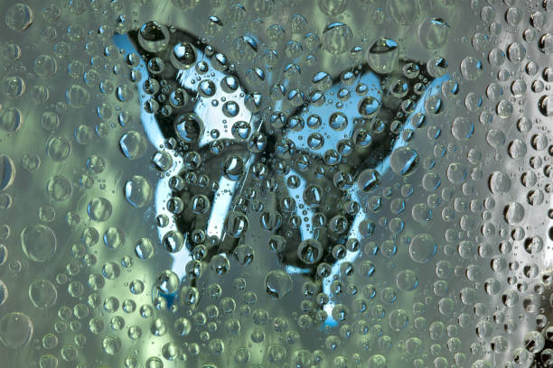 Malachite-blue spheres are located against the malachite-blue background with white-blue butterfly silhouette. Abstract fantasy. 3D render.