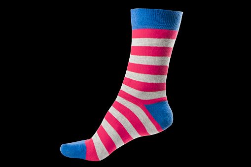 One volumetric sock with different lines isolated on black background. Colorful volumetric sock. Colored socks on the leg isolated on black background