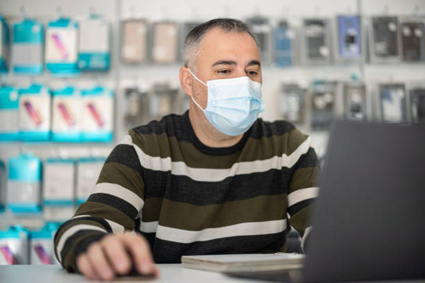 istock Worker in a shop wearing mask while working 1420692188
