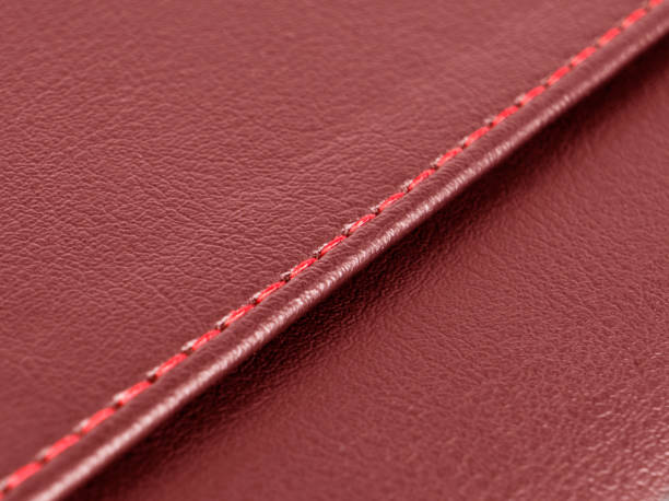 istock Red leather texture with red stitching. Part of perforated leather details. Red perforated leather texture background. Texture, artificial leather with diagonal red red stitching. 1420692234