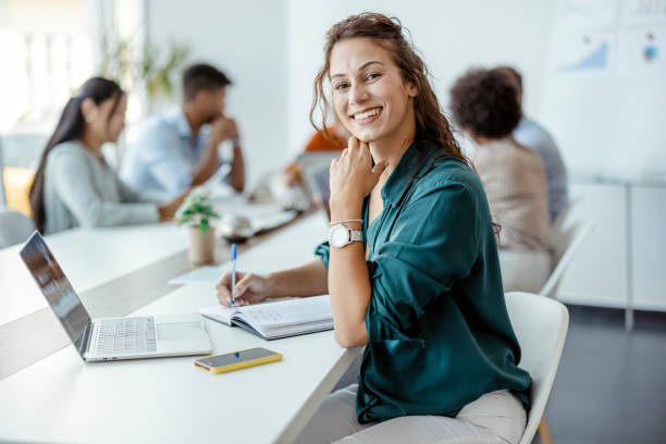 Leadership, Manager and Team Leader Female Employee Smiling in the Office, With Her Colleagues in Background. Shallow Focus 25 year old man portrait stock pictures, royalty-free photos & images