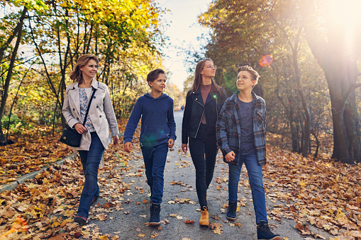 Mother and three teenage kids enjoying walk in autumn park.
Shot with Canon R5