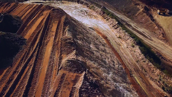 Top view of sand quarry, mining of natural resources or ore, heavy industry concept. Aerial of the quarry with many wheel traces.