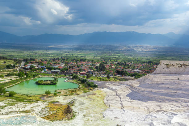Pamukkale, Turkey. View from cotton mountain with travertine terraces and geothermal springs against a stormy sky with clouds Pamukkale, Turkey. View from cotton mountain with travertine terraces and geothermal springs against a stormy sky with clouds denizli stock pictures, royalty-free photos & images
