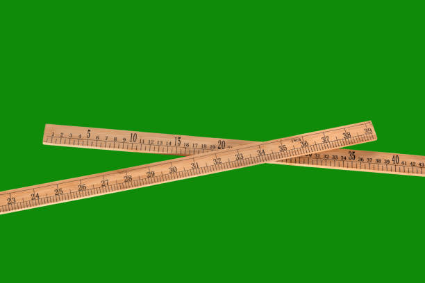 Tailor's wooden ruler on a neutral green background. Isolated