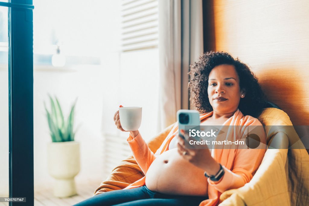 Brazilian ethnicity pregnant woman Pregnant woman at home looking through the window Bulgaria Stock Photo