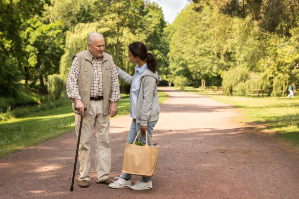 Senior man with wheelchair and caregiver stock photo