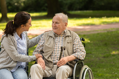 Senior man with wheelchair and caregiver